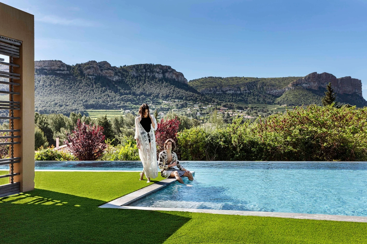 Gazon synthétique autour d’une piscine à débordement avec vue sur les montagnes
