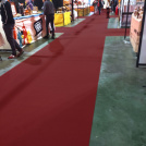 Moquette d’exposition filmée bordeaux, texture fine et uniforme pour espace pro