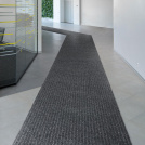 Tapis d'entrée côtelé antisalissures & antidérapant - Gris dans un couloir professionnel lumineux