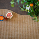 Zoom sur le bord galonné du tapis Mahé, forme organique et finition soignée