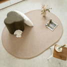 Tapis ovale en laine Mallow beige de forme ovale dans un salon lumineux