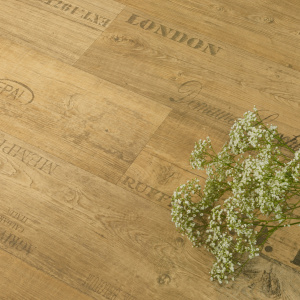 Sol Vinyle First imitation parquet marqué chêne miel, détail des veinures et inscriptions décoratives