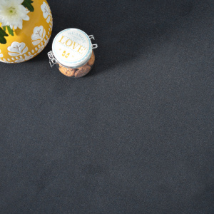 Détail de la moquette noire Loft Résist accompagnée d’un pot de biscuits
