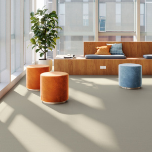 Sol vinyle Batimax Noralie T94 aspect lin beige grège dans un espace de détente lumineux avec banquettes orange et poufs colorés