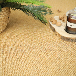 Tapis en sisal Tulum teinte miel avec planche en bois, noix et bougie dans une ambiance cocooning