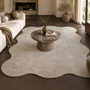 Tapis Pulse rectangulaire à bords ondulés argile beige, création exclusive Decoweb habillant un salon contemporain avec canapés clairs et table basse en marbre brun