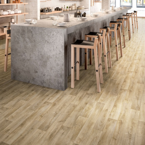 Revêtement PVC Batimax Tavel T18 aspect bois beige naturel, habillant le sol d'un espace de restauration contemporain