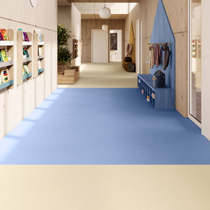 Sol vinyle Batimax Crystal T35 beige sable dans un couloir d'école, associé à un revêtement bleu et à des rangements colorés