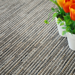 Moquette Bornéo Silver en gros plan avec tissage plat et fleurs colorées en décoration