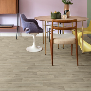 Sol vinyle Prestige Batitec - Tavel T31, aspect parquet bois grisé dans une salle à manger avec table en bois et mur mauve