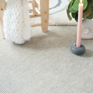 Moquette Nusa Blanc craie avec tissage bouclé et mobilier bois dans une ambiance naturelle