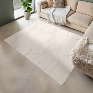 Tapis Flower Power crème en relief sous un canapé beige, pour une déco cocooning et élégante