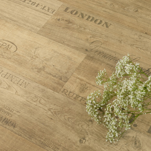 Sol PVC First effet parquet marqué chêne naturel, texture bois chaleureuse avec feuillage décoratif