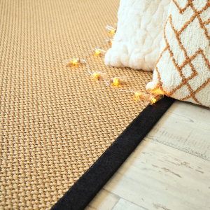 Tapis naturel en sisal Slow doré avec ganse chenille brun chiné dans une chambre élégante