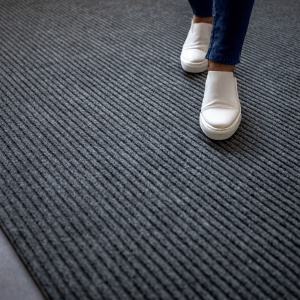 Tapis d’entrée gris sur mesure, contraste chic avec baskets blanches