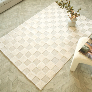 Tapis motif damier Petit Marius crème posé dans un salon lumineux et naturel