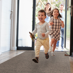 Tapis d'entrée antisalissures beige posé dans un couloir d’entrée, usage résidentiel
