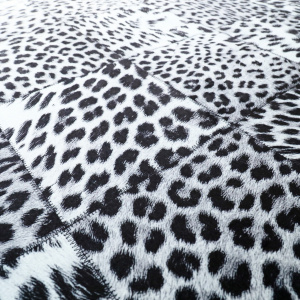 Détail du motif imprimé léopard en patchwork noir et blanc, alternance de textures visuelles animalières