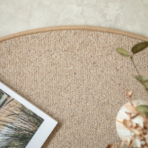 Détail du bord surjeté du tapis ovale Mallow beige en laine bouclée