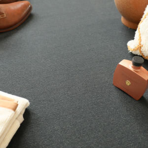 Chaussures en cuir et accessoires décoratifs disposés sur tapis velours Sylon Gris foncé