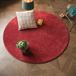 Tapis rond en velours galonné Rouge passion Feelings Balsan dans un salon à l’ambiance chaleureuse et feutrée