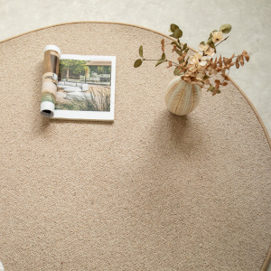 Tapis ovale Mallow beige en laine avec vase décoratif et magazine