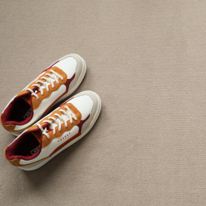 Chaussures et objets déco disposés sur un tapis sur mesure Sylon Tendre muscade en velours