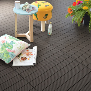 Dalles de terrasse composite brun foncé sous un salon de jardin