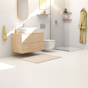 Sol vinyle Prestige Batitec - Coronet T10 aspect terrazzo blanc crème dans une salle de bain moderne avec meuble vasque en bois et douche vitrée