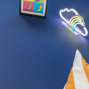 Sol PVC bleu marine uni Essentiel Color dans une ambiance créative associant décoration lumineuse et matières colorées