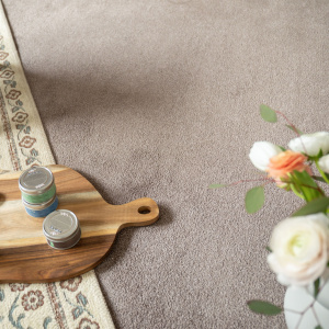 Moquette ultra douce Pulse taupe fumé, détail matière avec plateau bois et bouquet floral