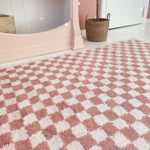 Zoom sur le tapis Colorama à damier rose vintage dans une chambre d’enfant