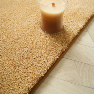 Tapis Select Camel avec finition soignée, ambiance cocooning avec bougie parfumée