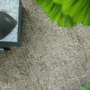 Moquette tissé plat Jambi gris perle avec plante verte et objets décoratifs dans une ambiance naturelle