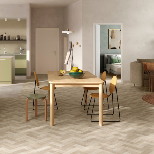 Sol vinyle Prestige Batitec - Sintra T45, parquet imitation bois en chevrons dans une salle à manger avec table en bois et canapé