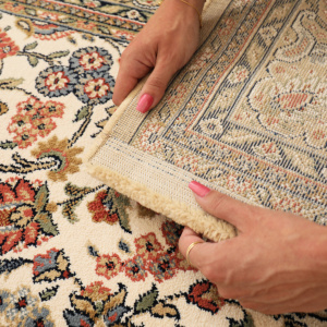 Zoom sur l’envers du tapis Mamie in love corail doux, motif floral et finition tissée