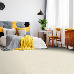 Moquette Re-life Vanille en fibres polyester recyclé dans une chambre cosy aux tons chaleureux et déco contemporaine