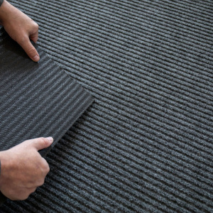 Détail du tapis gris, dos caoutchouc antidérapant et texture régulière