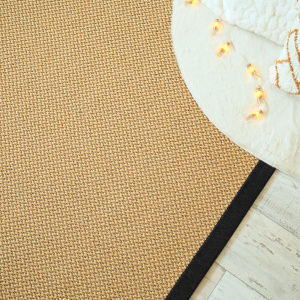 Tapis naturel en sisal Slow doré avec ganse chenille brun chiné dans une décoration minimaliste