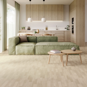 Sol vinyle Batimax Colmar T38 imitation parquet bois clair dans un salon lumineux avec canapé vert sauge et cuisine ouverte