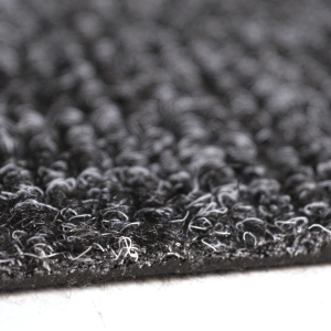 Zoom sur la texture bouclée de la dalle moquette anthracite avec détail matière et fibres résistantes