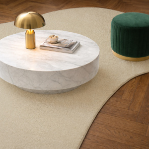 Tapis forme libre Hypnose beige nude associé à parquet chevron et mobilier design