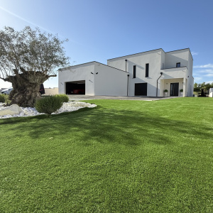 Gazon Cottage 38mm posé devant maison contemporaine, effet pelouse impeccable sans arrosage