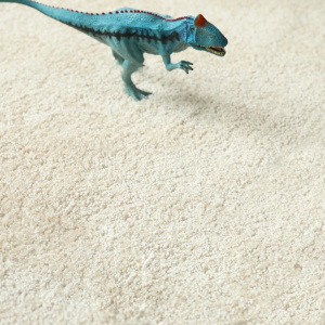 Zoom sur la texture de la moquette Lumicolor beige clair, douce et résistante dans une chambre d’enfant