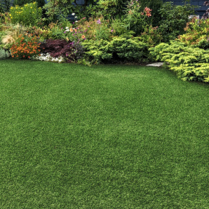 Gazon synthétique Vitalité 30 mm dans un jardin fleuri, rendu réaliste et sans entretien