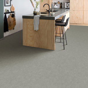 Sol vinyle Batimax Cosmos T91 aspect béton gris dans une cuisine moderne avec îlot central en bois et tabourets hauts