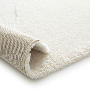 Tapis Stone crème enroulé montrant épaisseur 14 mm pour salon confortable
