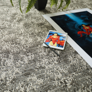 Moquette tissé plat Jambi nuances gris minéral avec magazine et objets déco dans une ambiance moderne