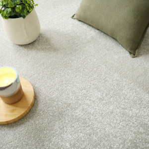 Dalle moquette velours gris perle avec plante et coussin dans une ambiance intérieure douce