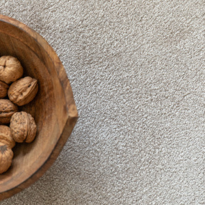 Moquette ultra douce Pulse argile beige, détail matière avec bol en bois et noix
